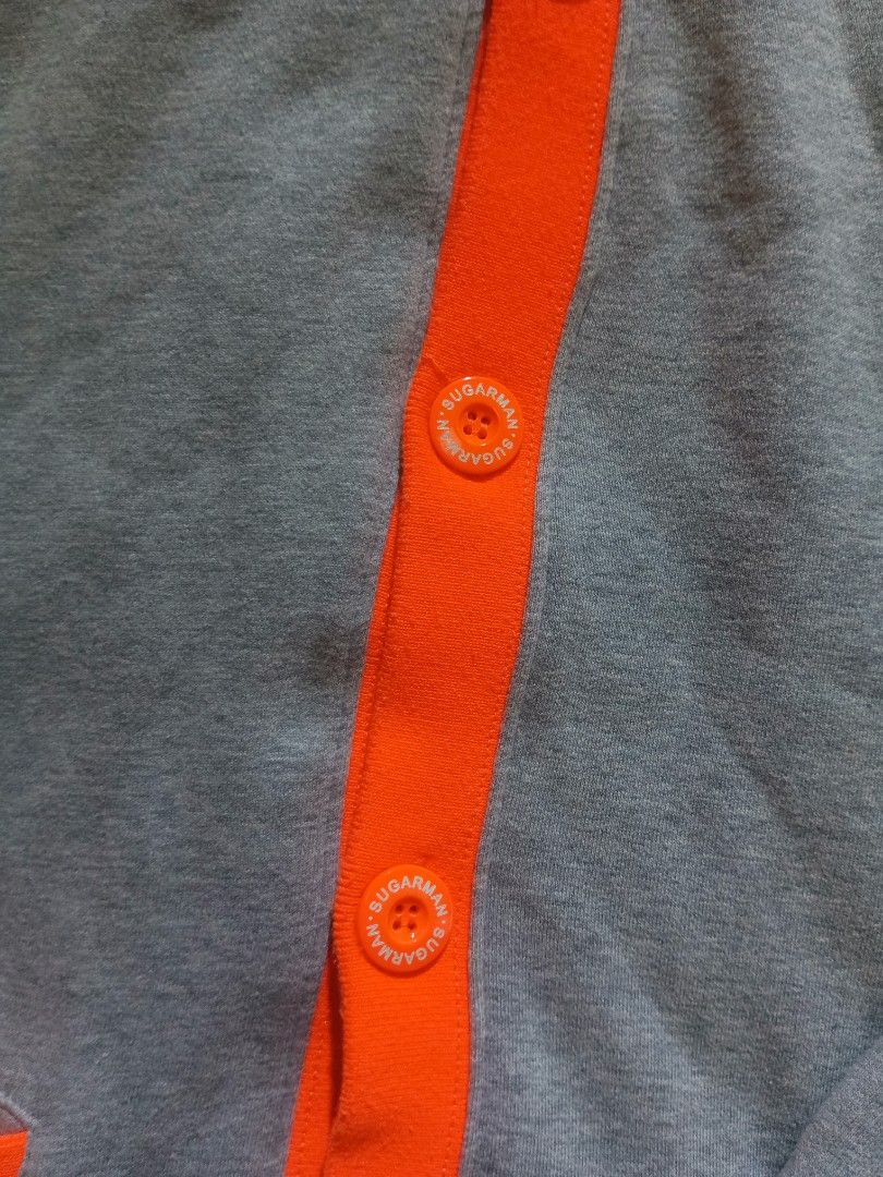 SUGARMAN BOTTON UP HOODIE (Category: Coats, Jackets and Outerwear) located in Manila. Submitted by overlytrim67 (Listing ID 1403307218, Image 3). Description: - Gray Sugarman Premium hoodie - Orange accents on cuffs and hood lining - Button-up front - Sugarman logo on front and back - Orange buttons with Sugarman logo - Front pocket NO ISSUE SIZE LARHE.