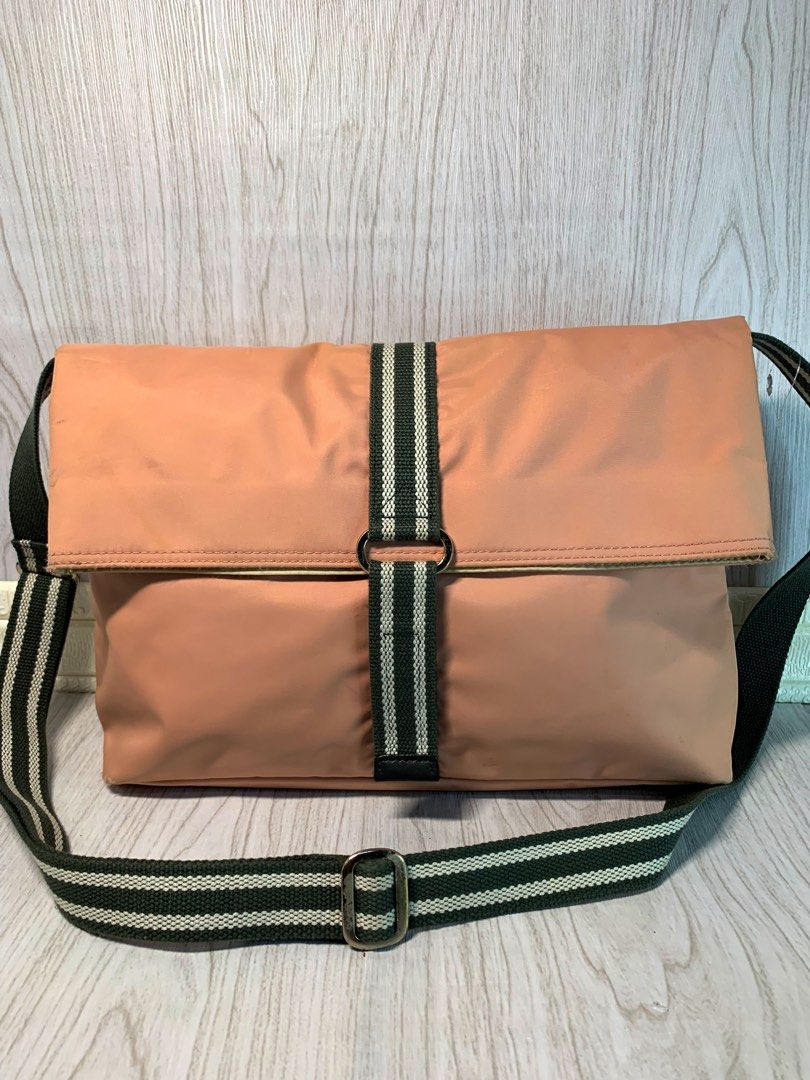 Agnes B. Voyage Shoulder Bag (Category: Shoulder Bags) located in Pasay City. Submitted by onick_79 (Listing ID 1403607342, Image 2). Description: Agnes B. Voyage Blush Pink Shoulder Bag Chic and feminine blush pink shoulder bag from Agnes B. Voyage. Features a flap closure, striped dark green and white strap, and a zip pocket on the back. The interior is spacious with a matching lining and logo detail inside. Measurement: L 38 × H 26 × W 9 cm St