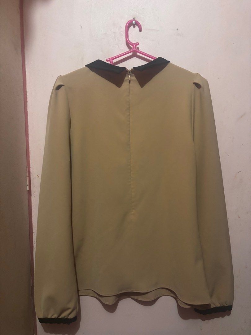 Beige Blouse with Black jeweled Collar (Category: Blouses) located in Pasig City. Submitted by kinderdrpt (Listing ID 1403558970, Image 3). Description: - Elegant beige blouse - Contrasting black collar with embellishments - Long sleeves with puff shoulders - Back zipper closure - Curved hemline - Black trim details - Suitable for various occasions.