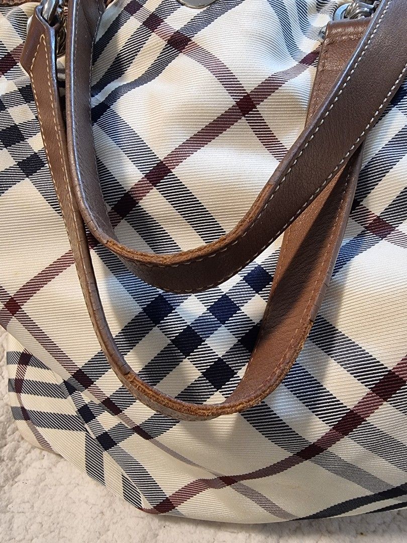 Burberry Blue Label Handbag (Category: Luxury Bags & Wallets) located in Quezon City. Submitted by kishey (Listing ID 1403587878, Image 2). Description: - Burberry Blue Label handbag - Brown leather straps and accents - Heart-shaped zipper pull - Branded interior label - Detachable strap - Exterior shows some stains but unnoticeable .