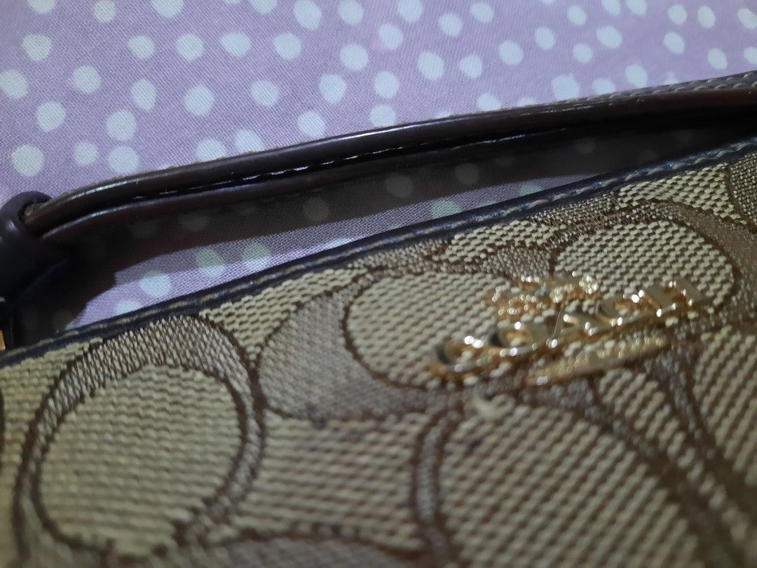 Coach Signature Wristlet (Category: Luxury Bags & Wallets) located in Manila. Submitted by anythingoesph (Listing ID 1403607454, Image 2). Description: - Coach wristlet - Signature brown and tan pattern - Wrist strap included - Secure zip closure.