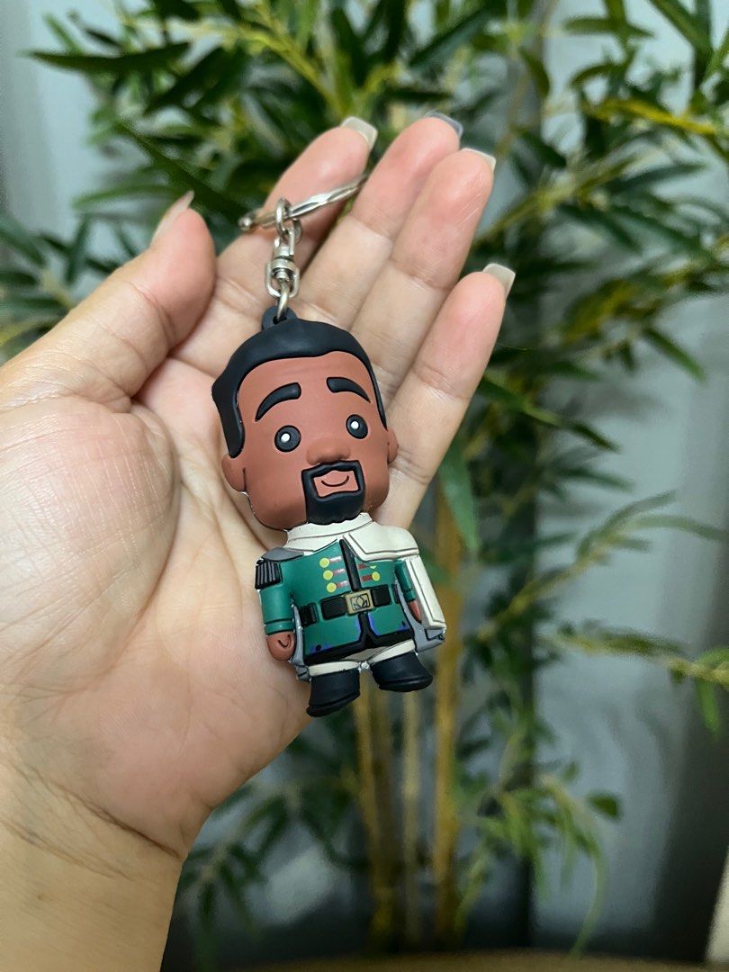 Disney Frozen M.I. Keychain (Category: Character Goods) located in Calamba. Submitted by thepinkpicksee (Listing ID 1403518213, Image 3). Description: - Disney character keychain - Features a character in green and white outfit - Silver ring included - Authentic Disney product - Collectible item - Disney logo and manufacturing details on the back.