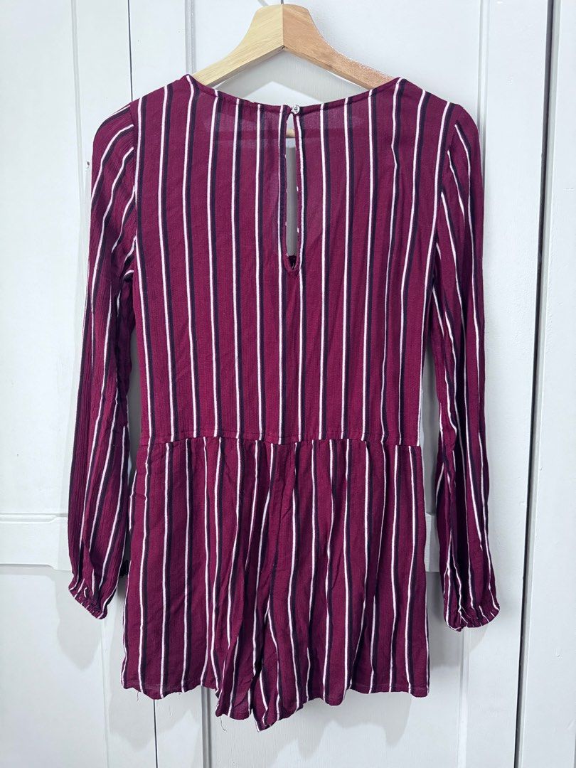 Hollister Striped Romper Fits M (Category: Rompers) located in Baguio. Submitted by makemegeli (Listing ID 1403487548, Image 2). Description: Hollister romper in a burgundy and white striped pattern. Features long sleeves, a V-neckline, and a drawstring waist. Includes pockets. The romper has a keyhole back and button details down the front. Size XS but can fit up to Medium. Very comfy, flowy material. .