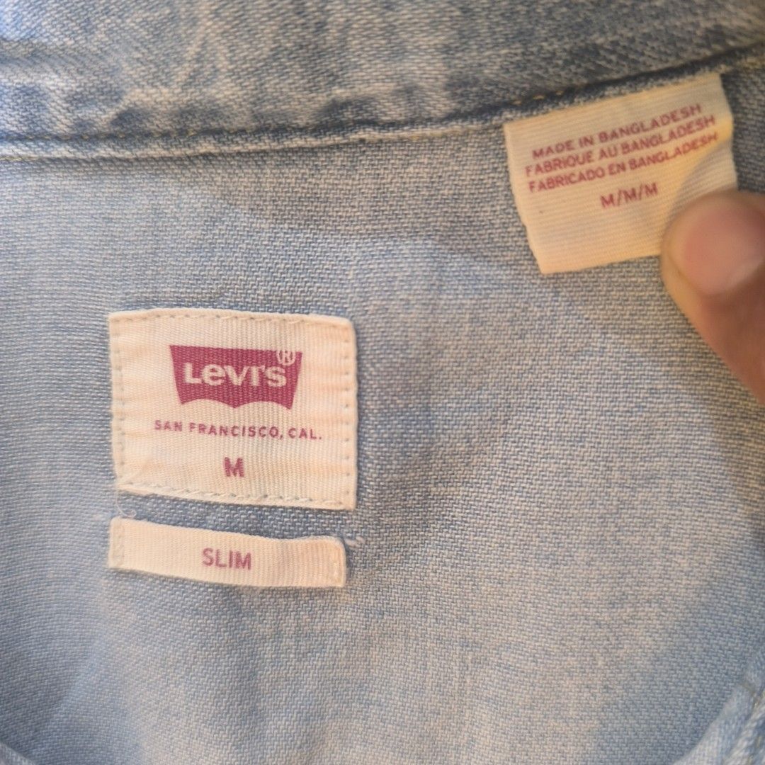 Levi's Denim Shirt - Slim Fit - Medium (Category: Tshirts & Polo Shirts ) located in Manila. Submitted by bienny-reyes98 (Listing ID 1403542469, Image 3). Description: - Light blue Levi's denim shirt - Size: Medium - Fit: Slim - Features two chest pockets - Button-down closure - Made in Bangladesh - Long sleeves with buttoned cuffs - Authentic Levi's.