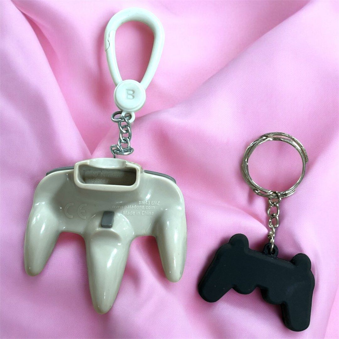 Nintendo 64 Controller Keychains (Category: Controllers) located in Calamba. Submitted by thepinkpicksee (Listing ID 1403517987, Image 2). Description: - Set of two Nintendo 64 controller keychains. - Includes a larger, classic N64 controller with a white clip and Nintendo logo. - Also includes a smaller, black controller. - Both have key rings attached. - Great for gamers and collectors!.