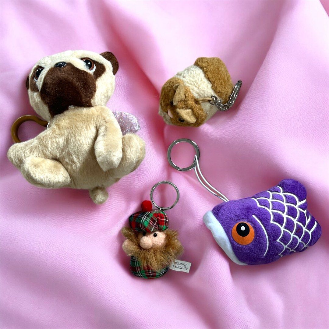Plush Keychain Set (Category: Plushies & Soft Toys) located in Calamba. Submitted by thepinkpicksee (Listing ID 1403518108, Image 1). Description: - Adorable plush keychains - Characters available: Pug with angel wings, guinea pig, purple fish, Scottish character - Features a metal ring for easy attachment - Perfect for keys, bags, and more! - Adds a touch of fun and personality.