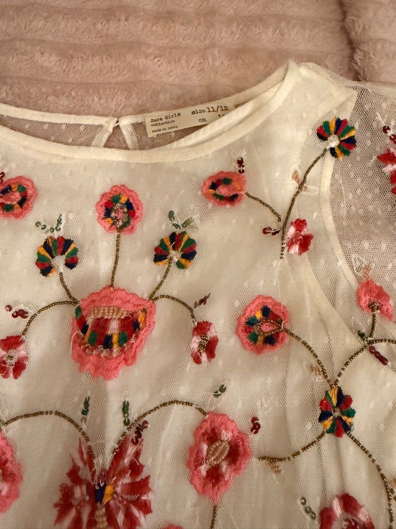 Zara Girls Embroidered Dress (Category: Dresses) located in Manila. Submitted by maryann22cabig (Listing ID 1403433467, Image 1). Description: Beautiful white dress from Zara Girls, featuring delicate floral embroidery. The dress has a round neckline and short sleeves. It is adorned with colorful floral embroidery on the bodice and a dotted tulle overlay. The size is 11/12. Perfect for special occasions or everyday wear..