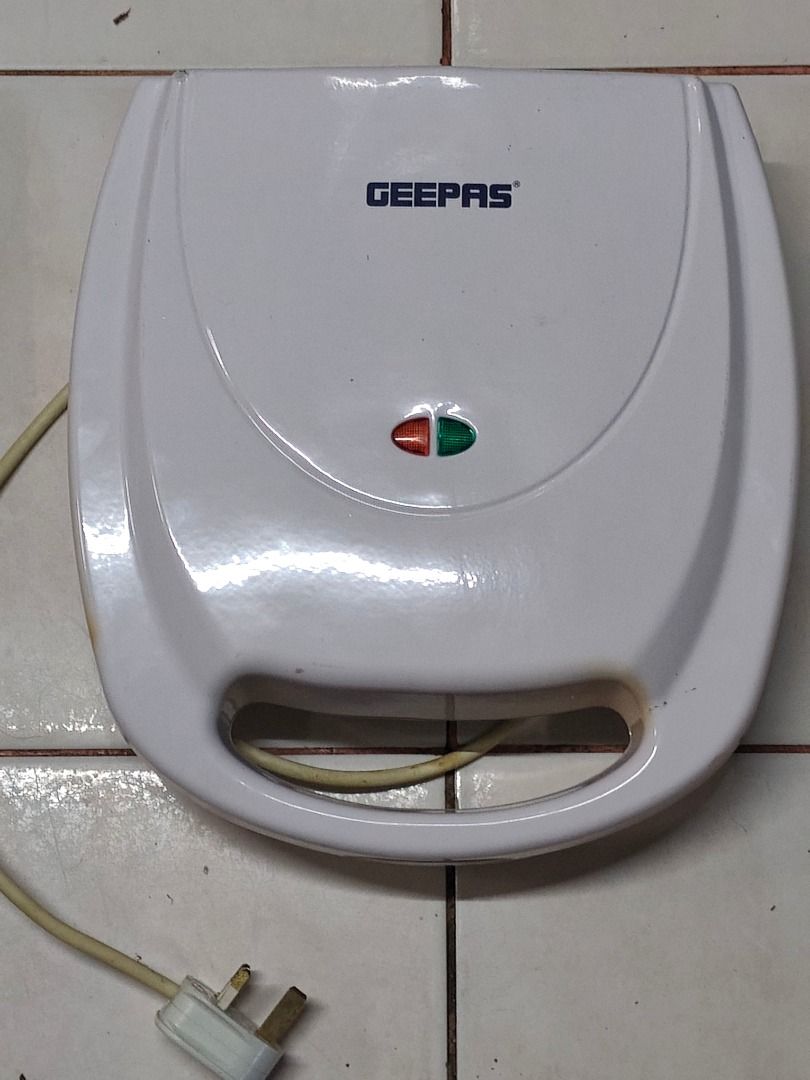 Geepas Mini Cake Maker GCM3762 (Category: Bakeware) located in Caloocan City. Submitted by meganshop3 (Listing ID 1403717383, Image 1). Description: Geepas mini cake maker. Model GCM3762. It has a white exterior with a handle. The power rating is AC 220-240V, 50/60Hz, 1400W. The plug is a type that fits into a three-pin outlet. The cake maker has an indicator light. Medj madumi lang bec sa pag store but overall working and good cond.
