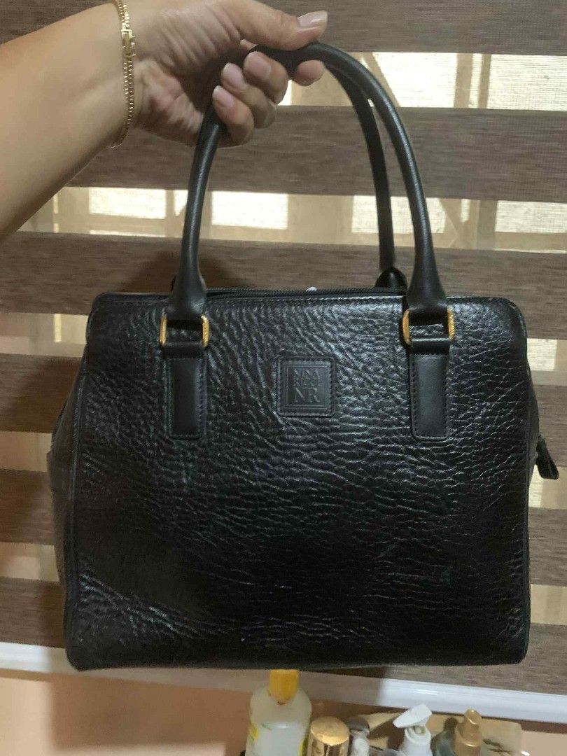 Nina Ricci Black Handbag (Category: Luxury Bags & Wallets) located in Aliaga. Submitted by akishaoshop2010. (Listing ID 1403669427, Image 1). Description: - Nina Ricci black handbag - Rectangular shape - Two handles - Zipper closure - Gold-toned hardware - Textured leather exterior - Lined interior - Small logo detail.