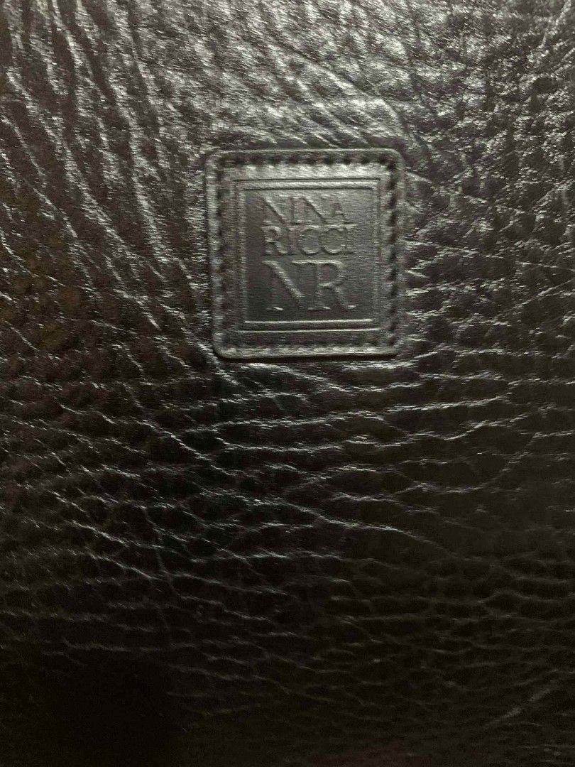 Nina Ricci Black Handbag (Category: Luxury Bags & Wallets) located in Aliaga. Submitted by akishaoshop2010. (Listing ID 1403669427, Image 2). Description: - Nina Ricci black handbag - Rectangular shape - Two handles - Zipper closure - Gold-toned hardware - Textured leather exterior - Lined interior - Small logo detail.