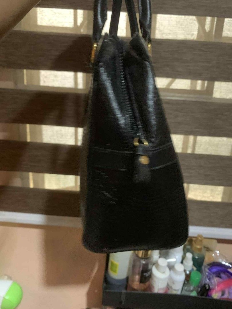 Nina Ricci Black Handbag (Category: Luxury Bags & Wallets) located in Aliaga. Submitted by akishaoshop2010. (Listing ID 1403669427, Image 3). Description: - Nina Ricci black handbag - Rectangular shape - Two handles - Zipper closure - Gold-toned hardware - Textured leather exterior - Lined interior - Small logo detail.