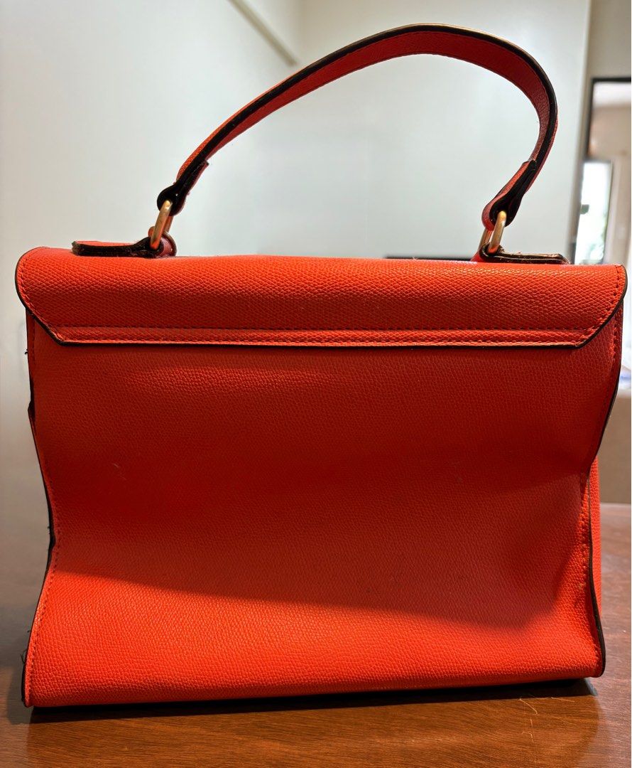 Aldo Handbag / Crossbody Bag (Category: Cross-body Bags) located in Taguig. Submitted by wountersdam (Listing ID 1403822039, Image 3). Description: Orange Aldo handbag that can be used as a handbag or crossbody bag. It is made of leather material and comes with a strap (leather and chain). The bag has a gold-colored clasp and a small gold chain with a charm. It has a handle on top and a flap closure. The bag can fit a lot. - Price slightly negoti