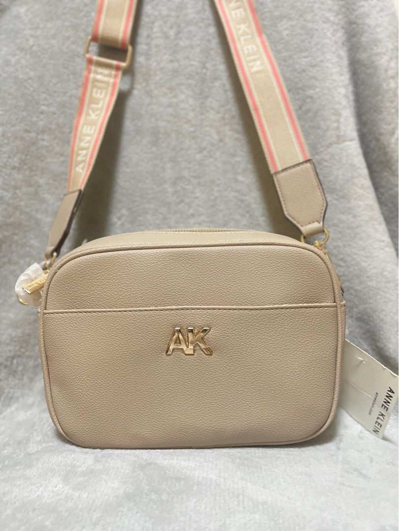Anne Klein Crossbody Bag (Category: Cross-body Bags) located in Mexico. Submitted by kjoybernabe (Listing ID 1403904815, Image 1). Description: Anne Klein crossbody bag features a beige exterior with a matching strap. It has a silver-tone AK logo on the front and a zippered main compartment. The bag comes with a detachable pouch. The strap has the Anne Klein logo printed on it..