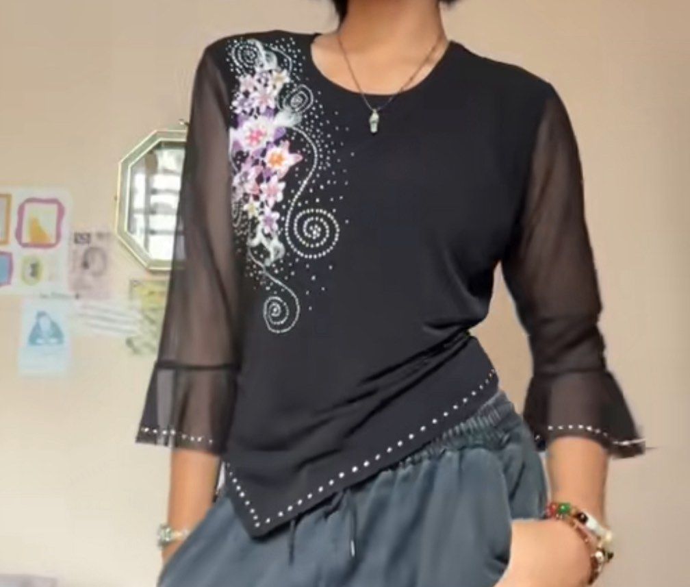Black Embellished Blouse with Mesh Sleeves (Category: Blouses) located in Pasig City. Submitted by feryclo (Listing ID 1403931388, Image 2). Description: - Black blouse - Floral embellishments - Mesh sleeves with flared cuffs - Asymmetrical hemline - Sparkling details - Versatile for various occasions.