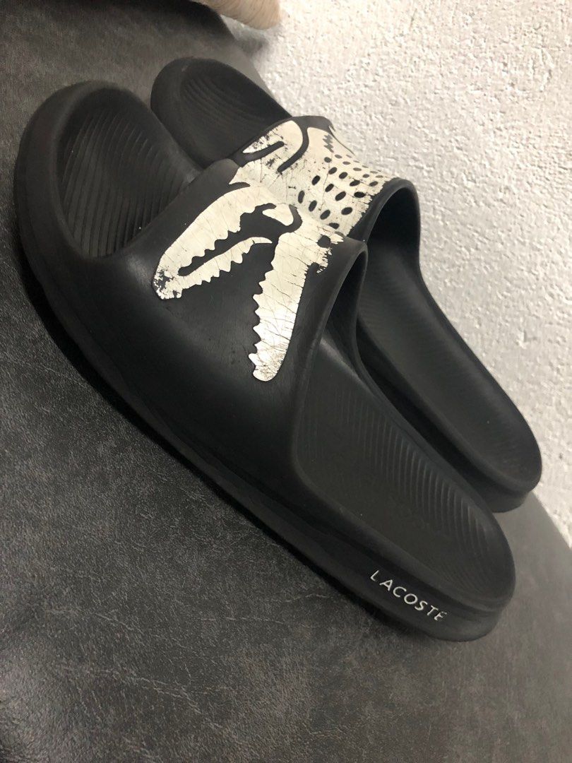 Lacoste Croco Slides (Category: Slippers & Slides) located in Manila. Submitted by thegreat21 (Listing ID 1403818115, Image 2). Description: Black Lacoste slides featuring the iconic crocodile logo. The slides have a textured footbed and the Lacoste logo is visible on the side. The soles show some wear. The slides are a classic design, perfect for casual wear..