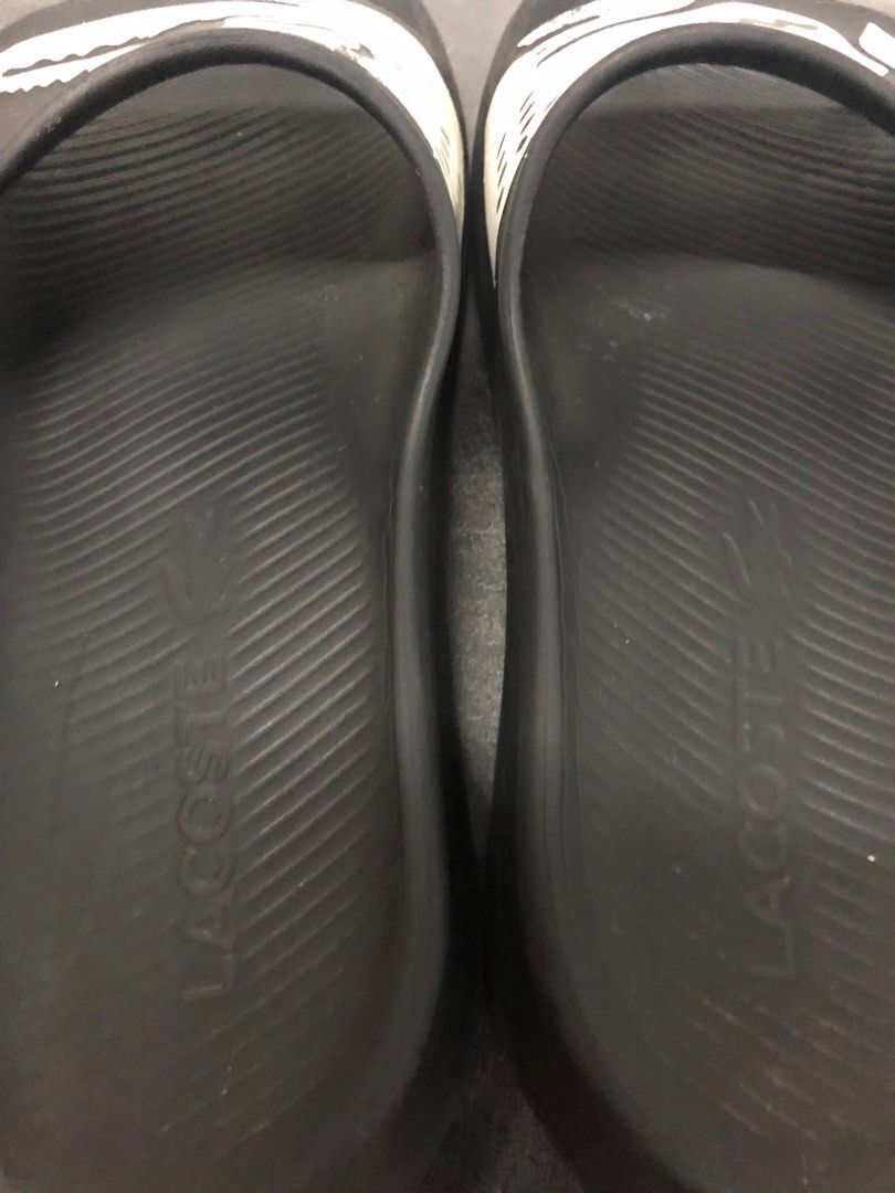 Lacoste Croco Slides (Category: Slippers & Slides) located in Manila. Submitted by thegreat21 (Listing ID 1403818115, Image 3). Description: Black Lacoste slides featuring the iconic crocodile logo. The slides have a textured footbed and the Lacoste logo is visible on the side. The soles show some wear. The slides are a classic design, perfect for casual wear..