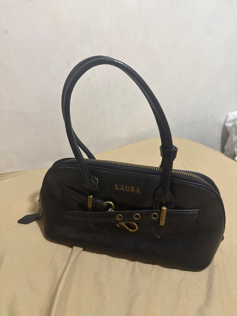 Laura & Shidai Black Handbag (Category: Purses & Pouches) located in Manila. Submitted by declutterwidme (Listing ID 1403822604, Image 1). Description: - Black handbag from Laura & Shidai - Top zipper closure - Two handles - Gold-colored clasp and hardware - Gray interior - Made in Seoul - Brand name "LAURA" on the front.