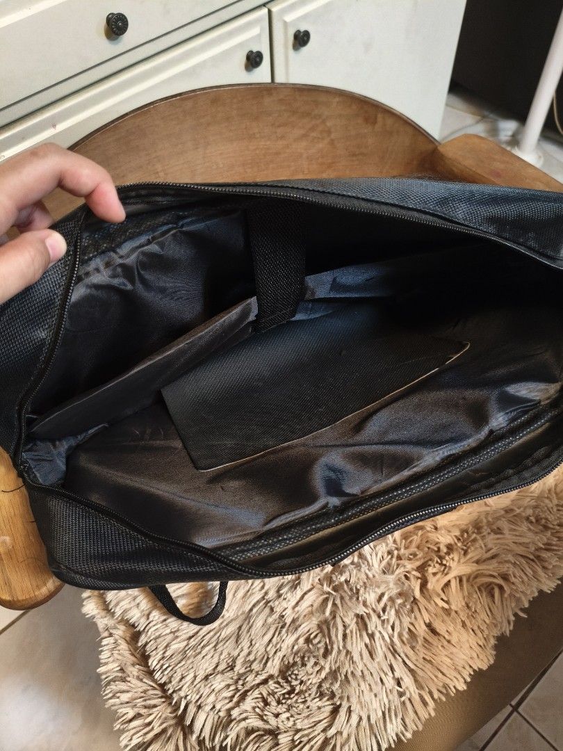 Lenovo Laptop Bag (Category: Laptop Bags & Sleeves) located in Imus. Submitted by umusthave23 (Listing ID 1403809340, Image 2). Description: Black Lenovo laptop bag with a shoulder strap and a handle. It has multiple compartments, including a main compartment and a front pocket. It has a padded shoulder strap for comfortable carrying. The bag is designed to protect a laptop during transport. selling low at 200 because of: issue: 1 strap needs to 