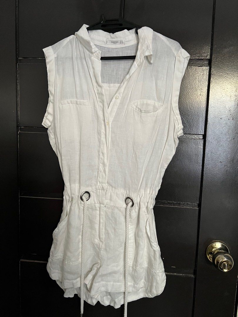 Mango White Sleeveless Romper (Category: Rompers) located in Davao. Submitted by safecloud.101e89 (Listing ID 1403808667, Image 1). Description: White sleeveless romper from Mango. Features a collared neckline, button-down front, and drawstring waist. Includes two front pockets and a back pocket. The romper has a short length and is made of a lightweight fabric. Perfect for warm weather..