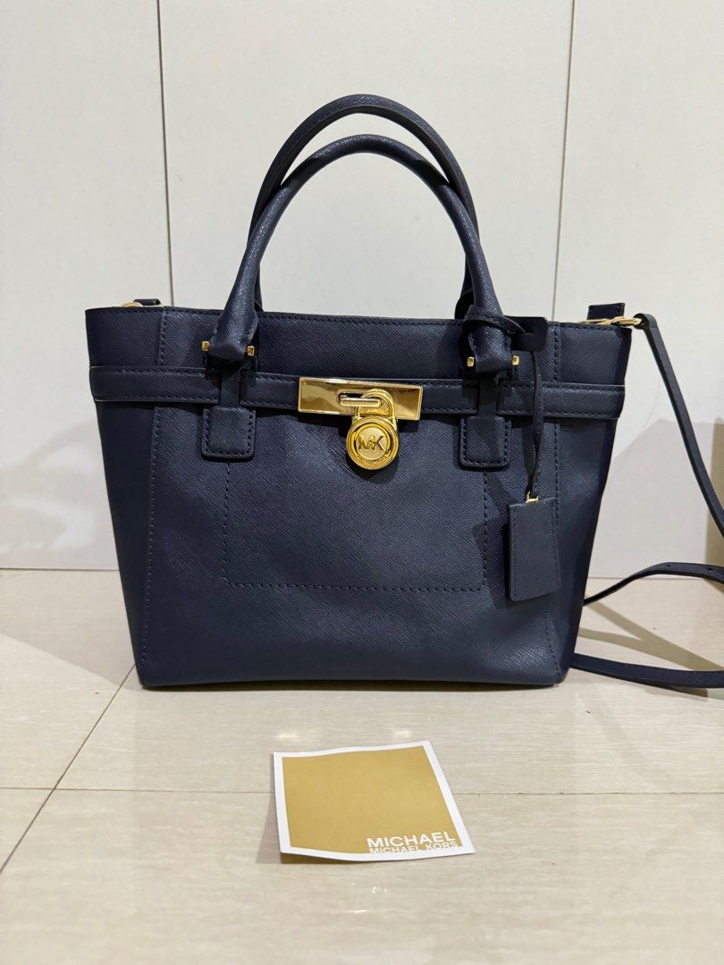 Michael Kors Hamilton Satchel Bag (Category: Luxury Bags & Wallets) located in Roxas City. Submitted by jhexxyyy (Listing ID 1403939216, Image 1). Description: - Michael Kors Hamilton satchel bag - Color: Navy blue - Gold-tone lock closure with MK logo - Detachable shoulder strap - Top handles - Interior zipper closure - Includes tag.