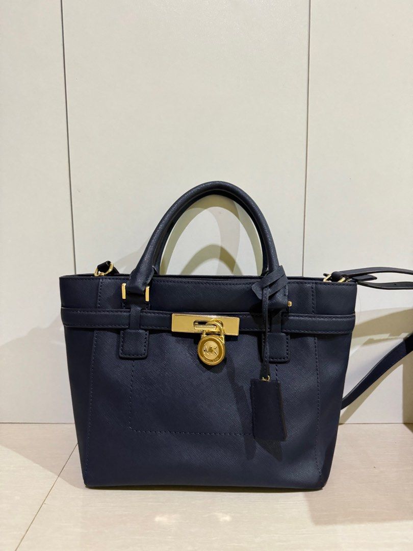 Michael Kors Hamilton Satchel Bag (Category: Luxury Bags & Wallets) located in Roxas City. Submitted by jhexxyyy (Listing ID 1403939216, Image 3). Description: - Michael Kors Hamilton satchel bag - Color: Navy blue - Gold-tone lock closure with MK logo - Detachable shoulder strap - Top handles - Interior zipper closure - Includes tag.