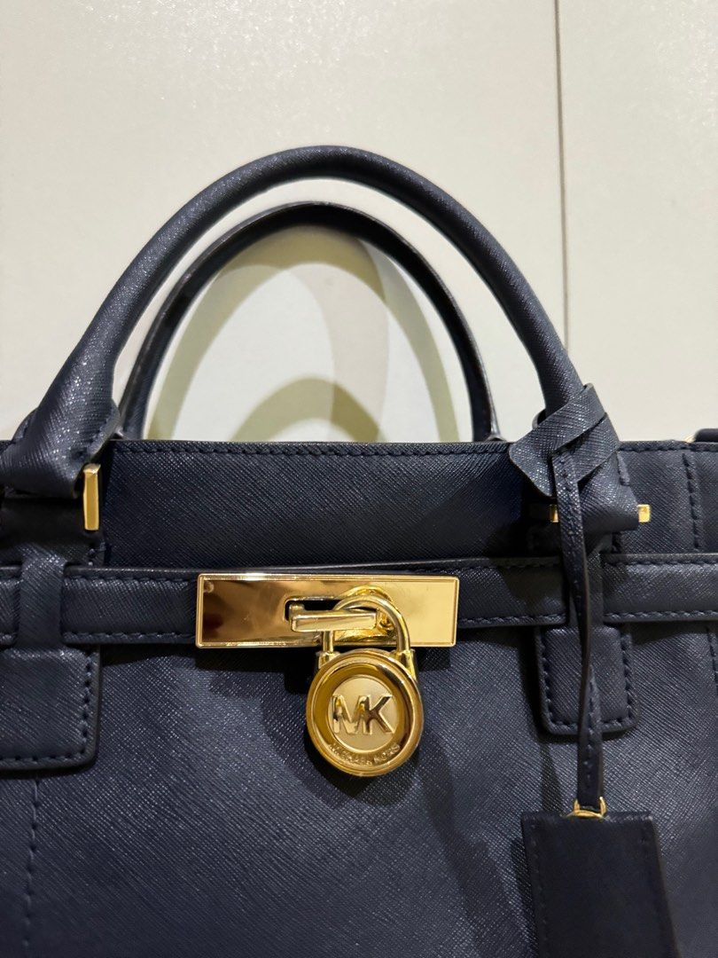 Michael Kors Hamilton Satchel Bag (Category: Luxury Bags & Wallets) located in Roxas City. Submitted by jhexxyyy (Listing ID 1403939216, Image 2). Description: - Michael Kors Hamilton satchel bag - Color: Navy blue - Gold-tone lock closure with MK logo - Detachable shoulder strap - Top handles - Interior zipper closure - Includes tag.