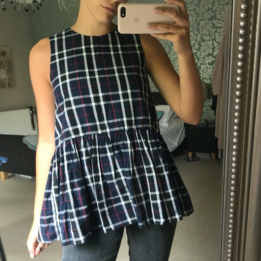 Zara Plaid Sleeveless Top with Ruffle Hem (Category: Sleeveless) located in Makati City. Submitted by secondavenue_ (Listing ID 1403870371, Image 1). Description: - Sleeveless plaid top in navy, white, and red. - Features a flattering peplum ruffle hem. - Unique tie-up back detail. - Lightweight fabric, ideal for warm weather. - Perfect for a casual chic look. - Used once only!.