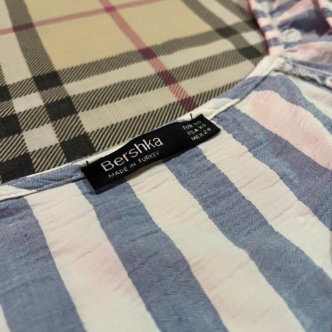 Bershka Tie-front Striped Crop Top (Category: Blouses) located in Manila. Submitted by _cxlx (Listing ID 1404128232, Image 2). Description: Size: XS (may fit semi-m) RFS: too fit for my liking Brand: Bershka Color: White-Blue Stripes Used only once Flaw: Missing button.