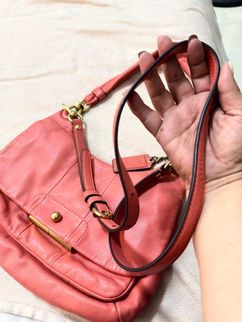 Coach Coral Leather Shoulder Bag (Category: Luxury Bags & Wallets) located in San Fernando. Submitted by trendyracks (Listing ID 1404006055, Image 2). Description: - Coral-colored Coach shoulder bag - Flap closure with gold-tone clasp - Detachable shoulder strap - Includes small Coach tag - Curved shape, made of leather - Front pocket under the flap.