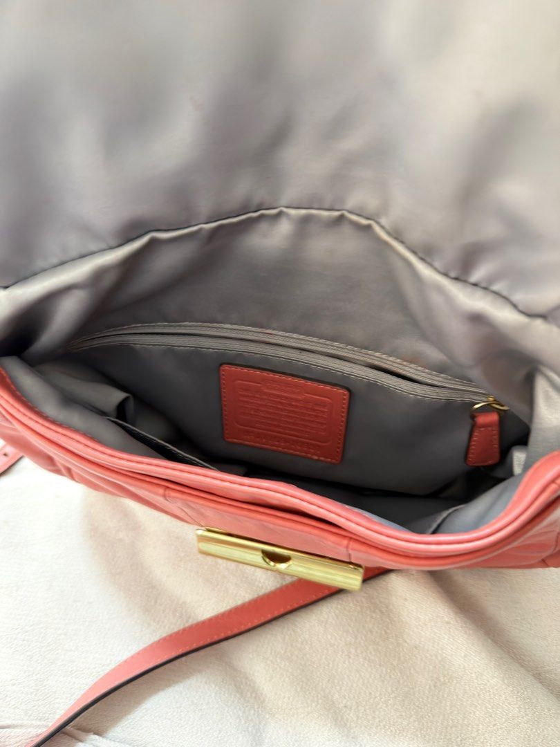Coach Coral Leather Shoulder Bag (Category: Luxury Bags & Wallets) located in San Fernando. Submitted by trendyracks (Listing ID 1404006055, Image 3). Description: - Coral-colored Coach shoulder bag - Flap closure with gold-tone clasp - Detachable shoulder strap - Includes small Coach tag - Curved shape, made of leather - Front pocket under the flap.