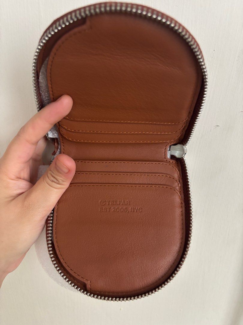 Telfar Circle Coin Purse (Category: Wallets & Card holders) located in Marikina City. Submitted by _aiiiks (Listing ID 1404052067, Image 1). Description: - Telfar Circle Coin Purse - Color: Brown - Features: - Zip closure - Telfar logo - Card slots - Coin compartment - Embossed interior: Brand name and "EST 2005, NYC" - Includes original box.