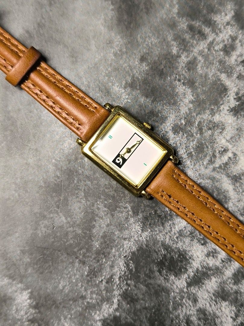 Virginia Slims Watch (Category: Women's Watches) located in Pasay City. Submitted by cassiuss (Listing ID 1404010928, Image 1). Description: Vintage Virginia Slims watch with a rectangular gold-toned case and a white dial. Features a unique flip-style display for the hour. The watch has a brown leather strap. The back of the watch is marked with "Virginia Slims" and "Stainless Steel". Japan movement, Very stylish..