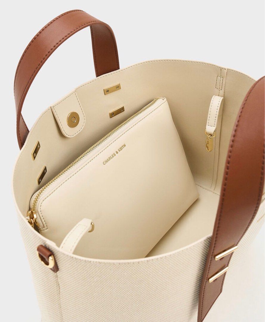 Charles & Keith Shania Canvas Tote Bag (Category: Tote Bags) located in Rizal. Submitted by decluttering.mess (Listing ID 1404286115, Image 2). Description: • Charles & Keith • brand new • bought from Japan • Shania Canvas tote bag Chocolate • double-handle, size L • this is soo cute, spacious but can also shrink into smaller form to suit your needs / match the occasion #charlesandkeith #bags #univbag #workbag #dailybag #japan #aesthetic.
