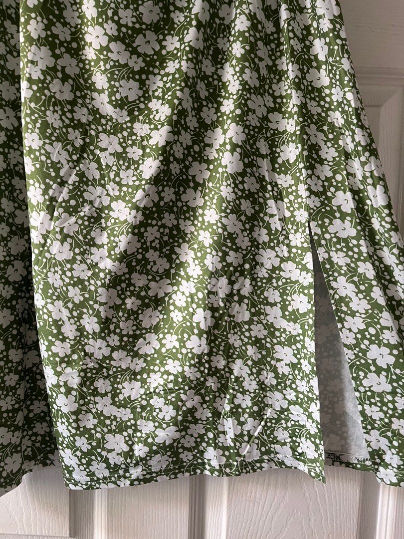 Floral Print Midi Skirt (Category: Skirts) located in Manila. Submitted by alexashops (Listing ID 1404239567, Image 3). Description: - Green midi skirt with white floral print - Elastic waistband - Side slit detail - Waist: Approximately 15 inches (unstretched) - Length: Approximately 27 inches - Lightweight and comfortable fabric.