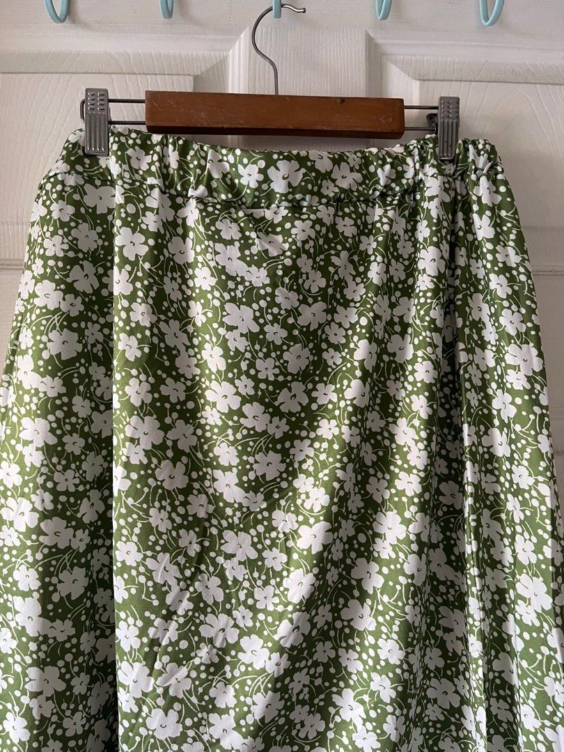 Floral Print Midi Skirt (Category: Skirts) located in Manila. Submitted by alexashops (Listing ID 1404239567, Image 2). Description: - Green midi skirt with white floral print - Elastic waistband - Side slit detail - Waist: Approximately 15 inches (unstretched) - Length: Approximately 27 inches - Lightweight and comfortable fabric.