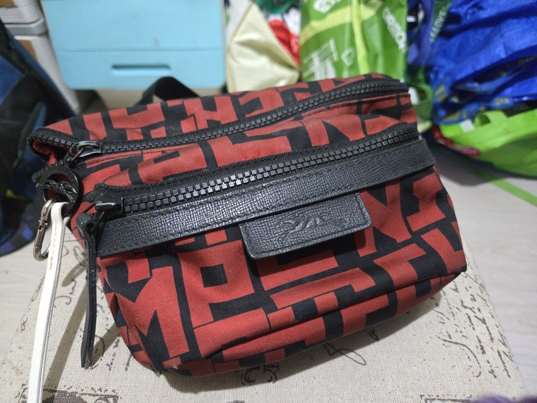 Longchamp Waist Bag Red and Black (Category: Luxury Bags & Wallets) located in Manila. Submitted by artefinds_ph (Listing ID 1404352880, Image 1). Description: - Longchamp waist bag - Color: Red and Black - Main compartment - Multiple card slots - Zippered pocket - Adjustable black strap - Buckle closure - Longchamp logo on front - Red interior lining.