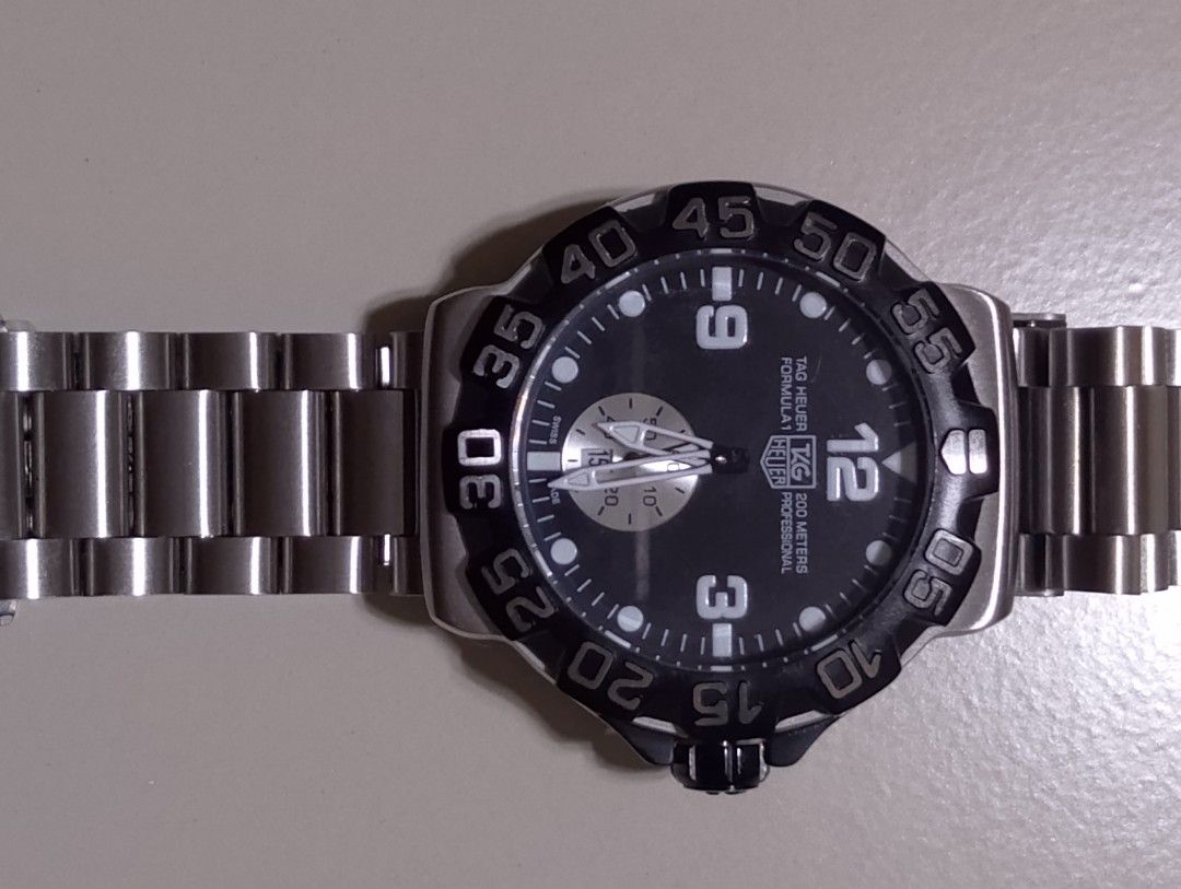 Tag Heuer Formula 1 200M Professional Watch (Category: Men's Watches) located in Quezon City. Submitted by jonathan_ilog18 (Listing ID 1404312994, Image 2). Description: - Tag Heuer Formula 1 watch - Black dial with luminous markers and hands - Stainless steel bracelet - Rotating bezel - Water-resistant to 200 meters - Date display at 3 o'clock - Folding clasp.