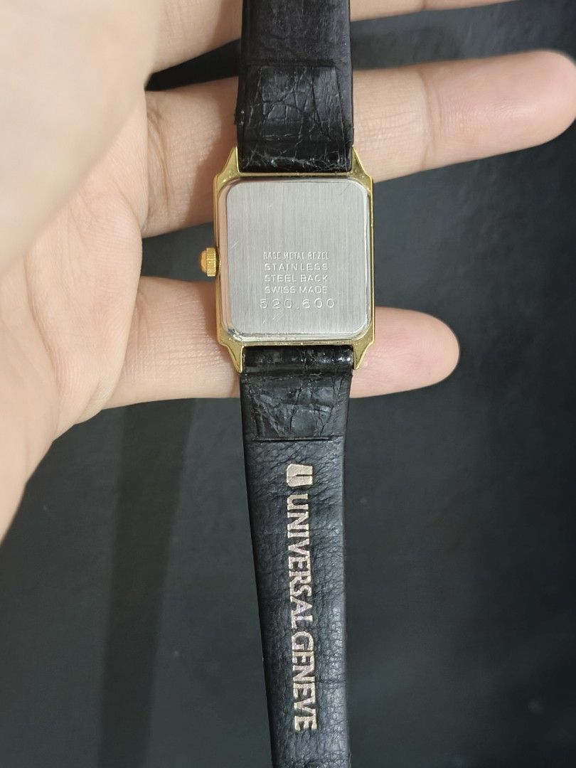 Universal Geneve Quartz Watch (Category: Luxury Watches) located in Taguig. Submitted by mercyeugen28914 (Listing ID 1404314483, Image 3). Description: Elegant Universal Geneve quartz watch with a rectangular gold-toned face. Features a black leather strap with a buckle closure. The watch face displays Roman numerals and a date window. The back of the watch is stainless steel. The strap is embossed with the brand name..
