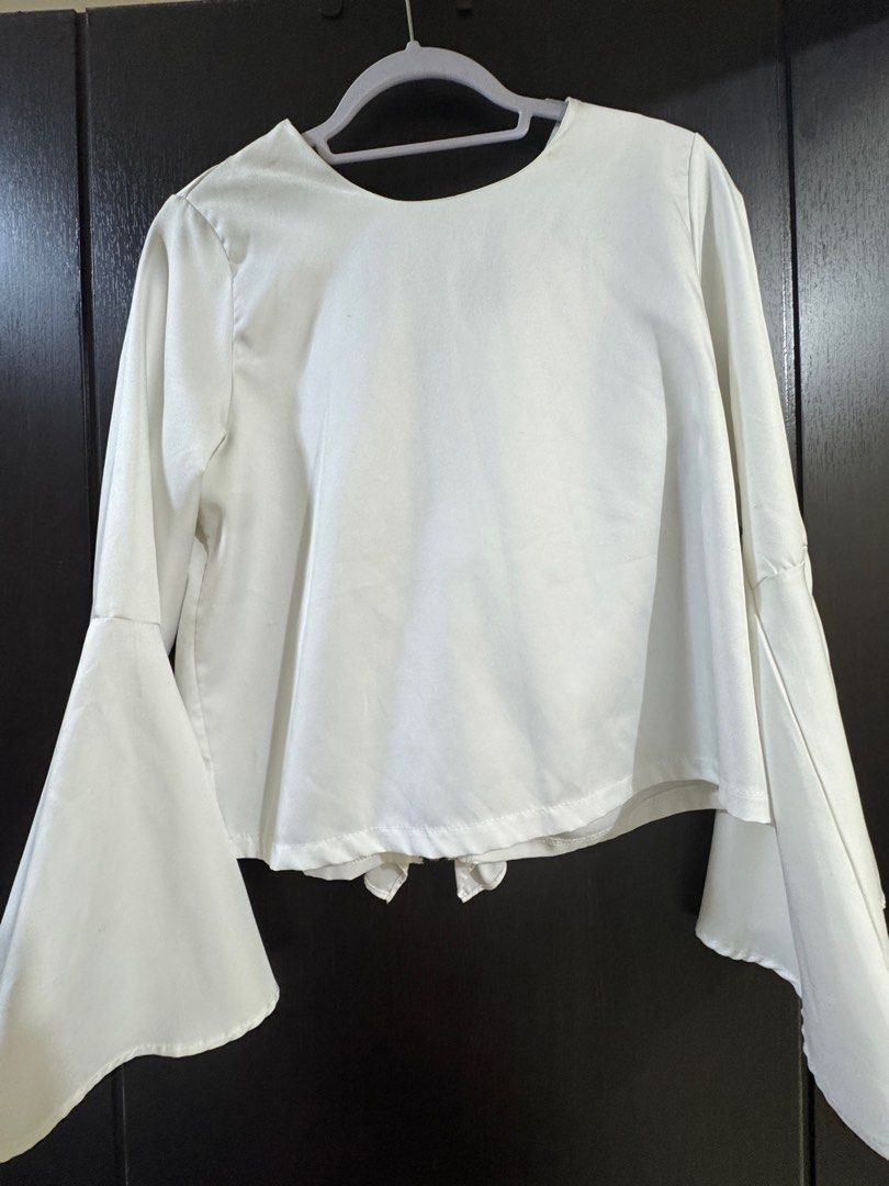 White Ruffle Front Blouse with Bell Sleeves (Category: Blouses) located in Manila. Submitted by elvbee (Listing ID 1404289432, Image 2). Description: Elegant white blouse featuring a ruffle front and stylish bell sleeves. It has a zipper closure and a round neckline. Can be worn 2 ways (zipper at the or at the front). This blouse is perfect for both casual and semi-formal occasions..