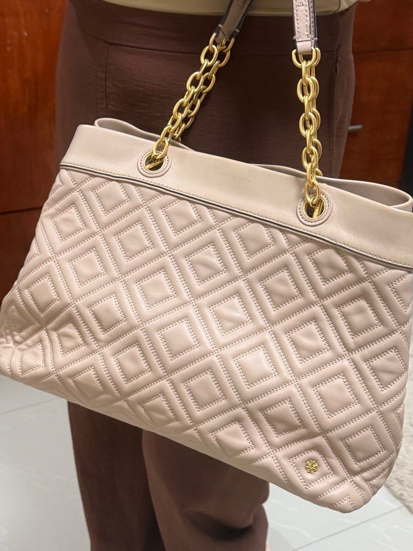 AUTHENTIC Tory Burch Quilted Tote Bag (Category: Luxury Bags & Wallets) located in Cebu City. Submitted by mikaylalcrs (Listing ID 1404453112, Image 1). Description: - Tory Burch tote bag - Quilted design - Gold-tone chain straps - Interior zippered pocket - Includes brand label - Neutral color - Suitable for everyday use - Spacious interior - Rarely used - No flaws.
