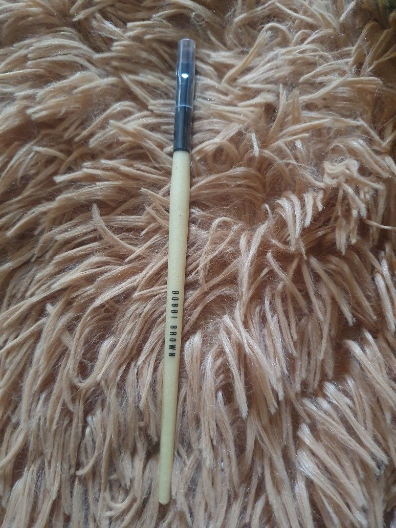 Bobbi Brown Smokey Eye Liner Brush (Category: Makeup) located in Pugo. Submitted by abshopfinity (Listing ID 1404383195, Image 1). Description: Authentic Bobbi Brown Smokey Eye Liner Brush. This brush is designed for precise application of eyeliner. The brush has a wooden handle with the Bobbi Brown logo and the words "Smokey Eye Liner" printed on it. The brush head is angled for easy application. It is a great tool for creating a smokey eye look