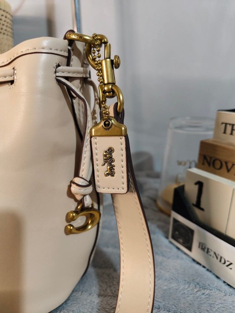 Coach Camila Bucket Bag (Category: Luxury Bags & Wallets) located in Valenzuela. Submitted by boutiquechic (Listing ID 1404422464, Image 3). Description: NO FLAWS ‼️ - Cream-colored Coach Camila bucket bag - Drawstring closure - Detachable shoulder strap - Gold-tone hardware - Includes Coach hangtag.