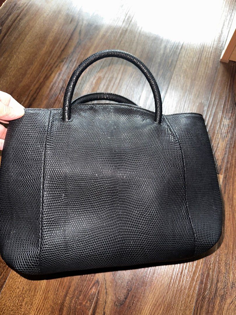 JRA Black Leather Handbag (Category: Luxury Bags & Wallets) located in Mandaluyong City. Submitted by TheWeekendProject (Listing ID 1404443721, Image 2). Description: - Black leather handbag - Textured exterior - Has its signature JRA metal tag - Two handles - Multiple compartments, including zippered pockets - Metal feet on the bottom - Well-constructed - 11” x 10” x 3.5”.