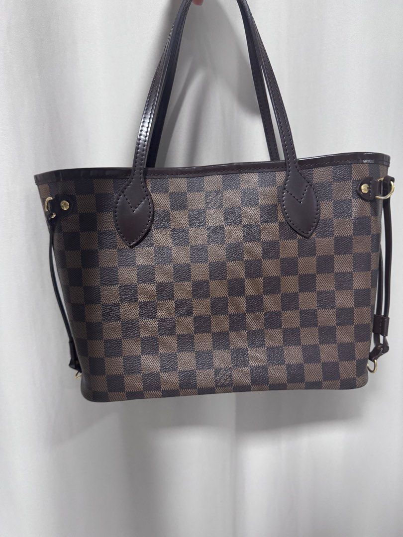 Louis Vuitton Damier Ebene Neverfull MM (Category: Luxury Bags & Wallets) located in Manila. Submitted by decluterthings888 (Listing ID 1404497044, Image 1). Description: - Authentic Louis Vuitton Neverfull PM - Damier Ebene canvas - Brown leather handles and trim - Gold-tone hardware - Spacious interior - Adjustable side laces - Classic and versatile tote.