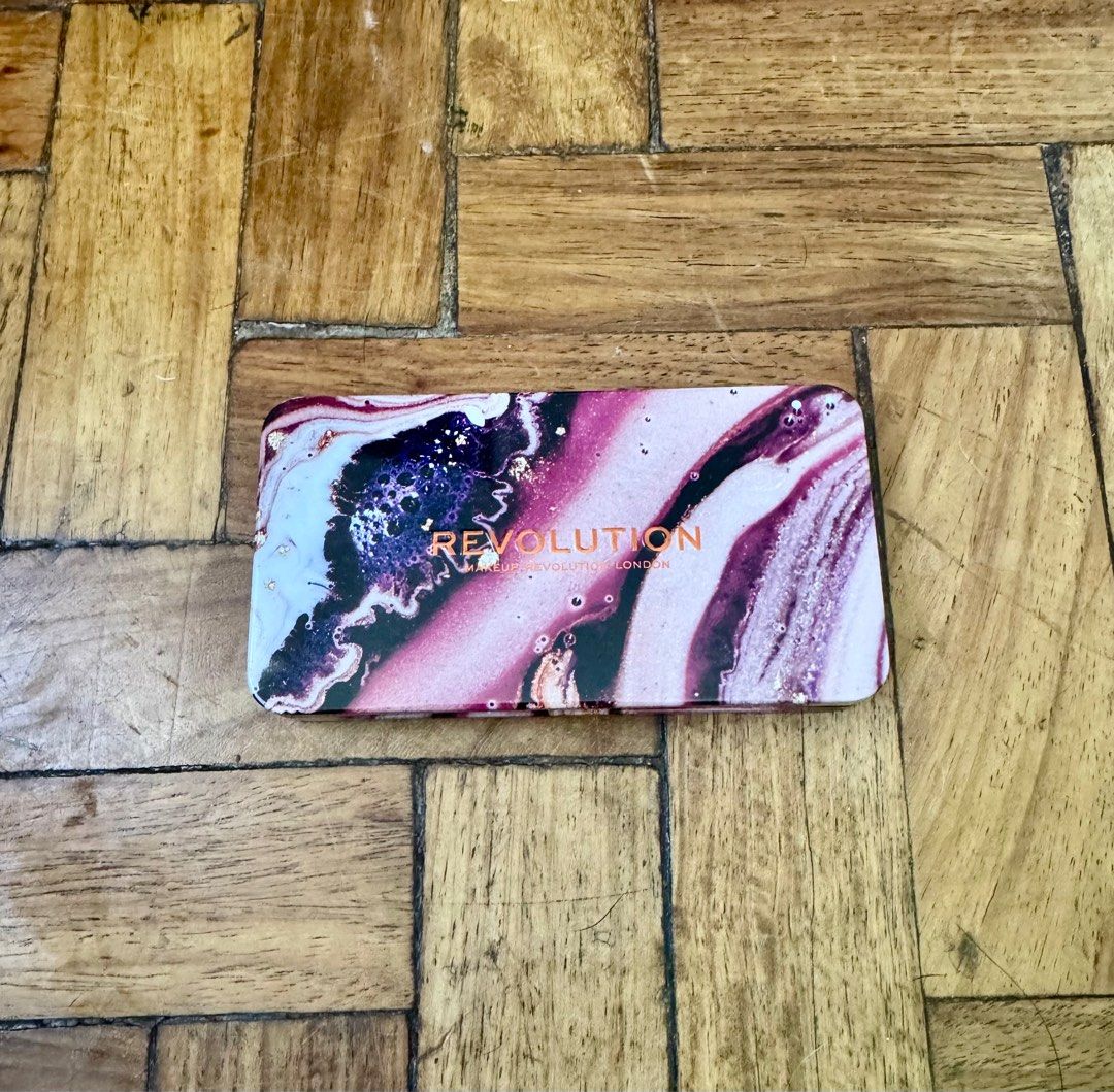 Revolution Forever Dynamic Allure Eyeshadow Palette (Category: Makeup) located in San Juan City. Submitted by bel2025 (Listing ID 1404372156, Image 2). Description: - Revolution eyeshadow palette - Features pink, purple, and neutral shades - Includes a mirror - Contains 8 eyeshadow colors - Ingredient information on the back - Compact and travel-friendly.