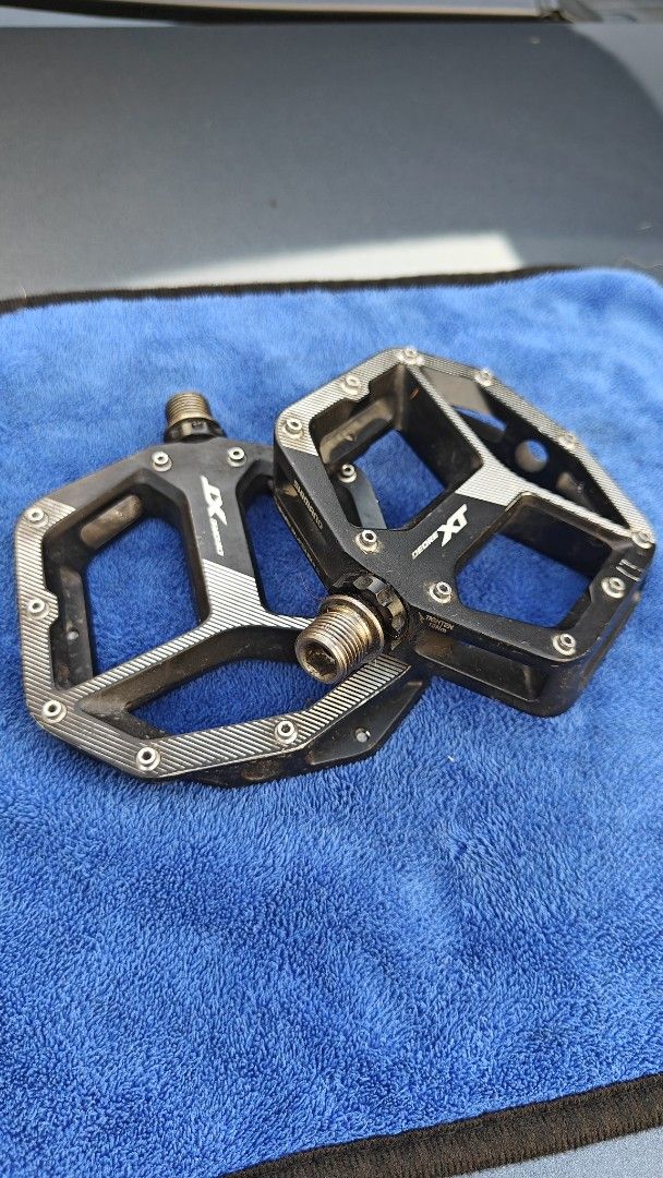 Shimano XT Pedals (Category: Bicycles) located in Calamba. Submitted by andreip05 (Listing ID 1404445915, Image 2). Description: - Shimano XT pedals - Black and silver color scheme - Platform style - Textured surface for enhanced grip - Visible spindle - Designed for mountain biking - Features the Shimano XT logo Seldom used,previously installed on a track bike. Bike is sold and selling these pedals separately. no issues, set and forget. XT legnd