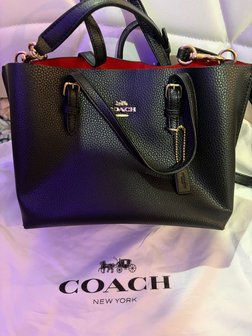 Coach Black Handbag (Category: Luxury Bags & Wallets) located in Manila. Submitted by nookeeph (Listing ID 1404642440, Image 1). Description: - Black Coach handbag - Red interior - Top handle and detachable shoulder strap - Gold-tone hardware - Includes Coach dust bag - Textured leather exterior - Classic design - Coach logo on front.