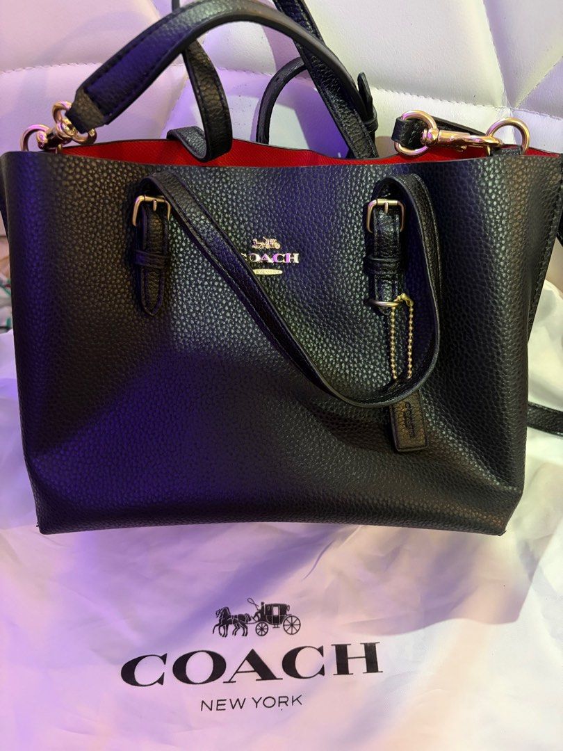 Coach Black Handbag (Category: Luxury Bags & Wallets) located in Manila. Submitted by nookeeph (Listing ID 1404642440, Image 2). Description: - Black Coach handbag - Red interior - Top handle and detachable shoulder strap - Gold-tone hardware - Includes Coach dust bag - Textured leather exterior - Classic design - Coach logo on front.