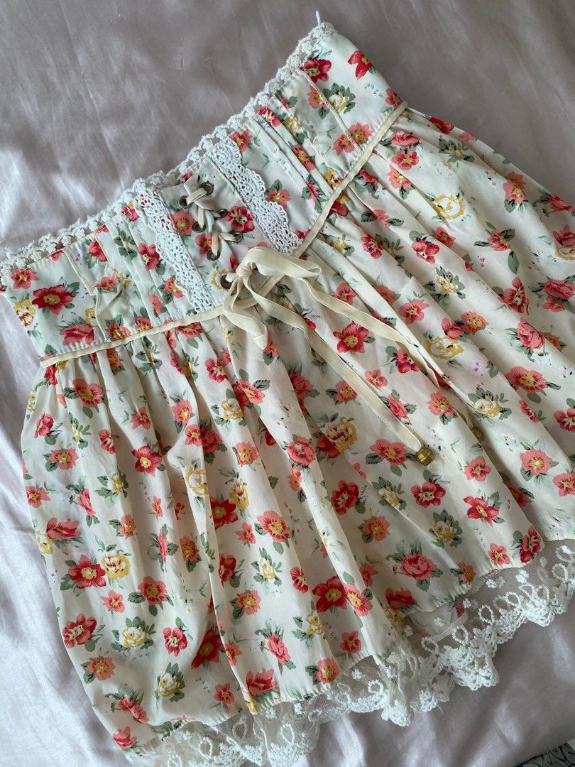 Floral Lace Trim Skirt (Category: Skirts) located in Manila. Submitted by herwears (Listing ID 1404746196, Image 2). Description: - Cream-colored skirt with red and yellow floral print. - Features delicate lace trim. - Corset-style waist with ribbon tie. - Lightweight fabric, ideal for warm weather..