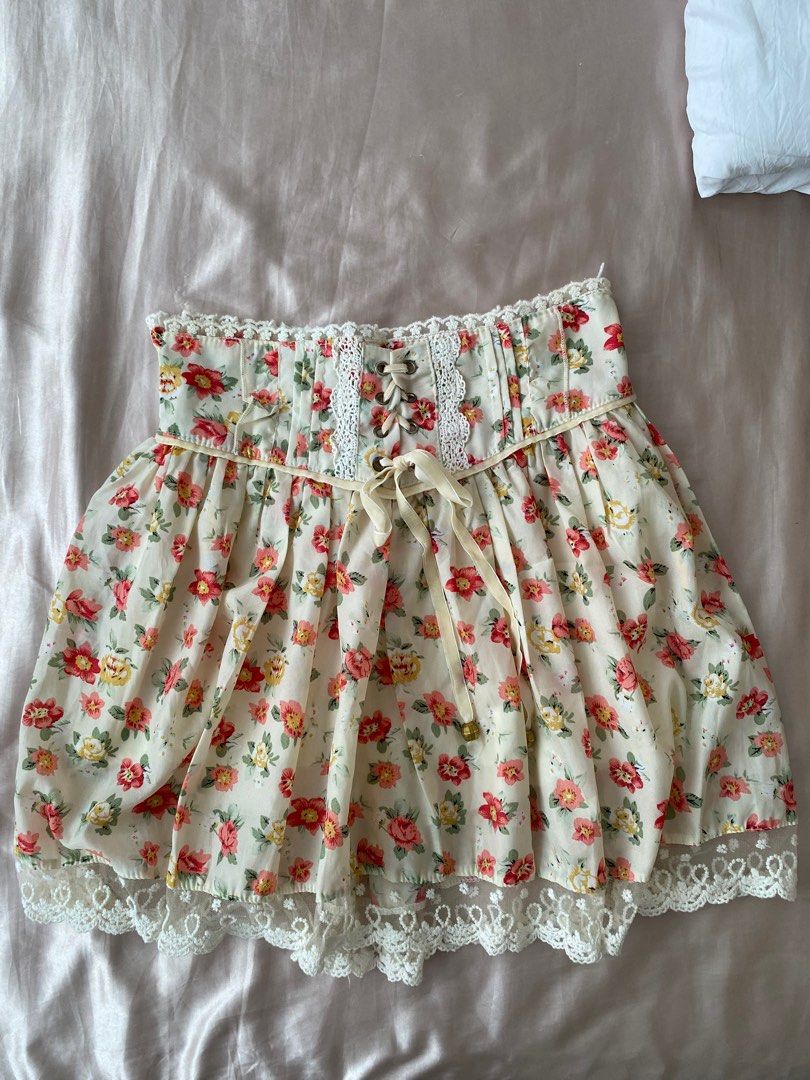 Floral Lace Trim Skirt (Category: Skirts) located in Manila. Submitted by herwears (Listing ID 1404746196, Image 1). Description: - Cream-colored skirt with red and yellow floral print. - Features delicate lace trim. - Corset-style waist with ribbon tie. - Lightweight fabric, ideal for warm weather..